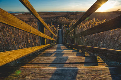 Footpath leading to bridge against sky