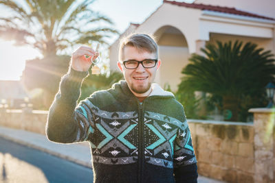 Portrait of young man standing against built structure