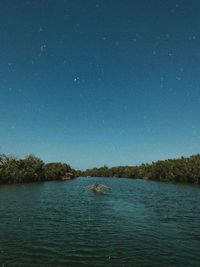 Scenic view of lake against clear sky at night