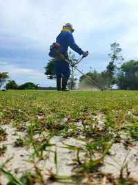 Man working on field against sky