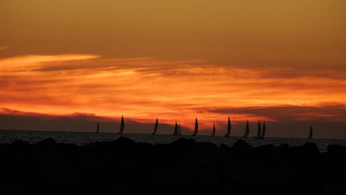 Boats in calm sea against scenic sky