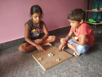 Siblings playing on floor, indian game ludo, game member 2/3/4 ,
