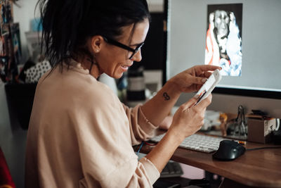 Side view of woman using mobile phone