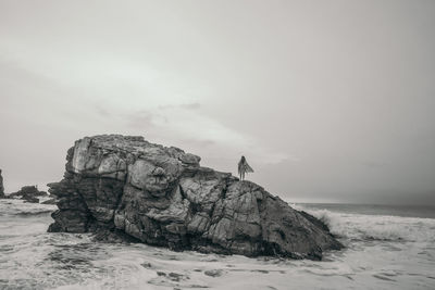 Rock formations on shore against sky