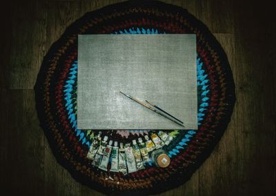High angle view of paintbrushes and canvas on place mat