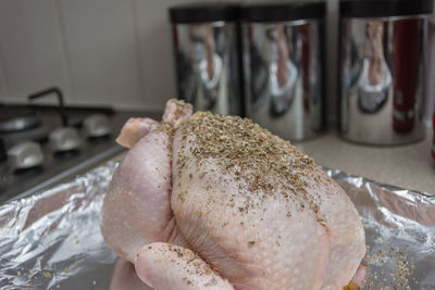 Close-up of seasoned chicken on baking sheet at table