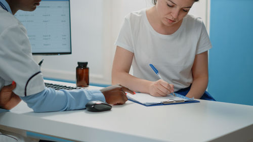 Midsection of doctor examining patient in office