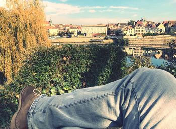 Low section of man on river against sky