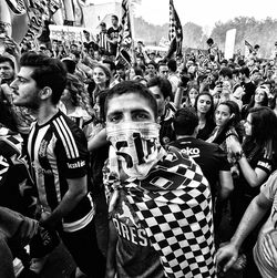 Portrait of man standing against large group of people