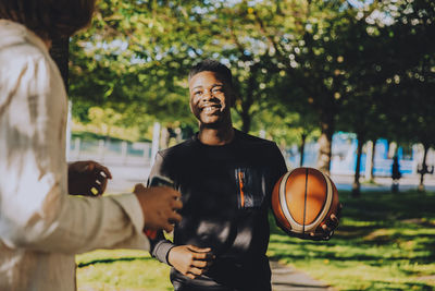 Man and woman standing by basketball court