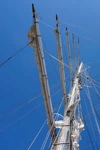 Low angle view of sailboat against blue sky