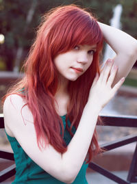 Portrait of beautiful young woman standing against tree