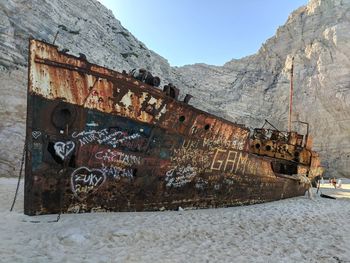 Abandoned boat on mountain against sky