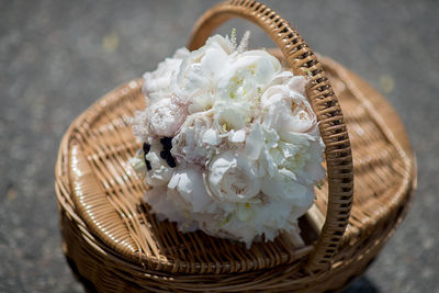 High angle view of peony flowers bouquet on wicker basket