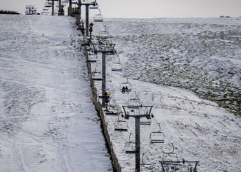 High angle view of snow covered land and sea against sky