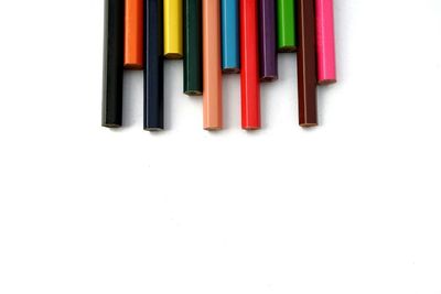 High angle view of multi colored pencils over white background