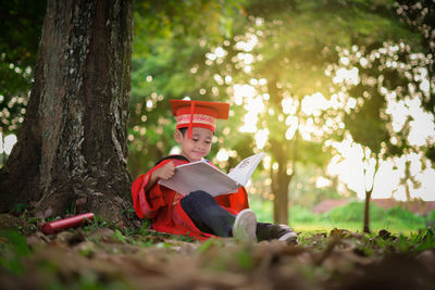 Man sitting on guitar in forest