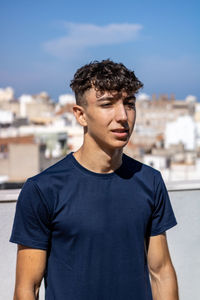 Portrait of young man standing against sky