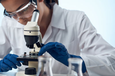 Midsection of scientist examining chemical in laboratory