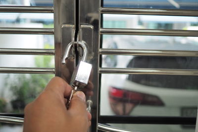 Close-up of hand holding glass window