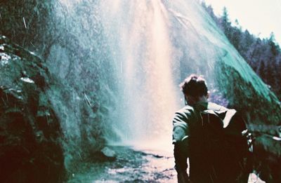 Rear view of man photographing water