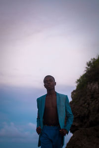 Portrait of a teenager standing against sky