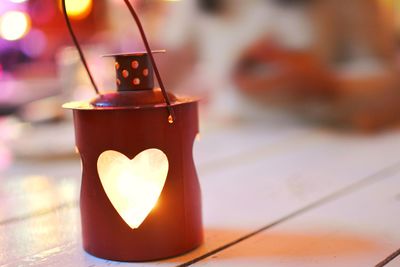 Close-up of lit candle on table