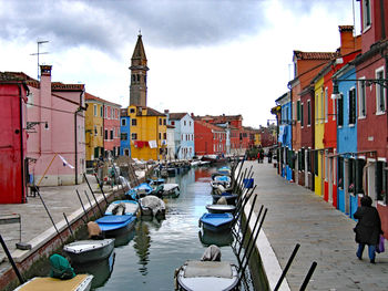 Boats in canal amidst buildings in city