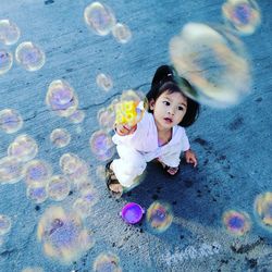 High angle view of girl playing in bubbles