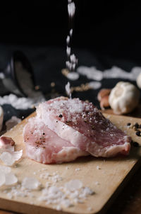 Close-up of meat with salt on cutting board