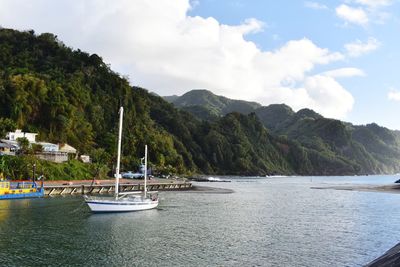 Sailboats moored on sea against sky