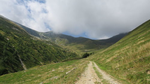 Scenic view of road amidst mountains against sky