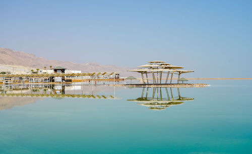 Reflection of built structure in dead sea  against clear sky