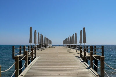 Pier in sea against clear sky