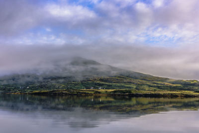 Scenic view of lake by mountain against sky