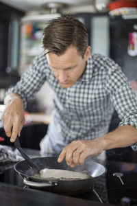 Man cooking fish in kitchen