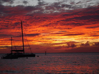 Silhouette of sailboat on sea against dramatic sky