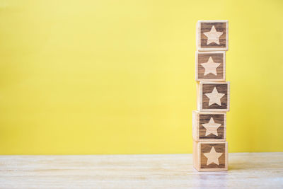 Close-up of stack of table against yellow background