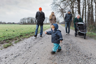 Family walking on dirt road during winter