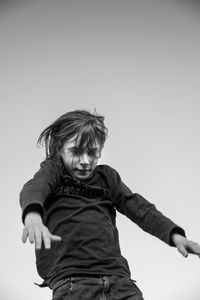 Low angle view of boy against clear sky