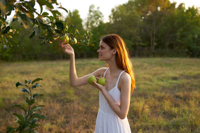 Side view of young woman lying on field