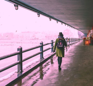 Full length rear view of woman walking on water