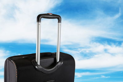 Close-up of luggage against cloudy sky
