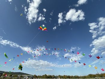 Low angle view of kites flying against sky