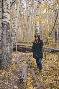 Full length of woman standing in forest during autumn