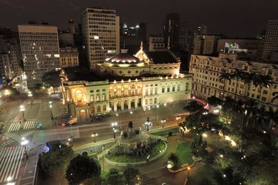 High angle view of illuminated street amidst buildings at night