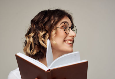 Portrait of smiling young woman reading book