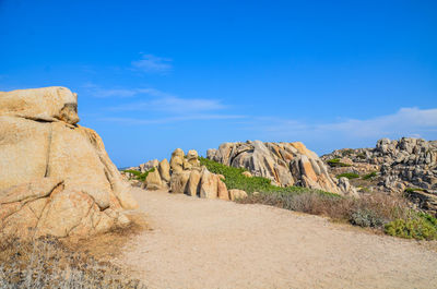 Rock formations on landscape against blue sky