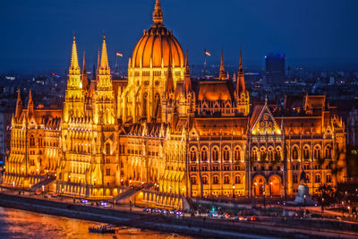 Illuminated buildings in city against sky at night