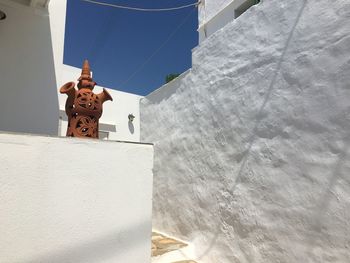 Low angle view of cross on building against sky